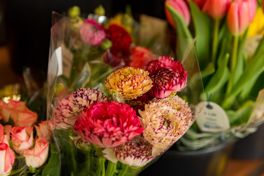 Bunte Blumensträuße in Folie verpackt in der Floristikabteilung.