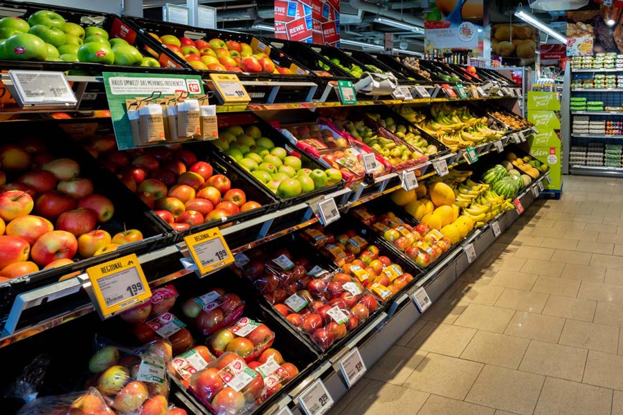 Obst- und Gemüseabteilung mit bunt gefüllten Regalen im Supermarkt.